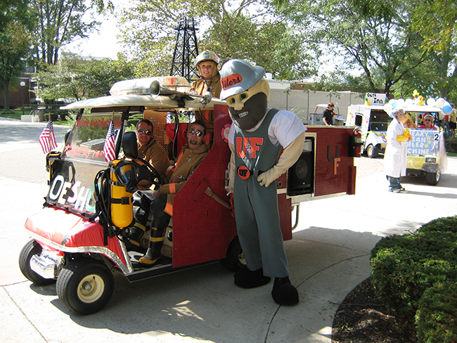 UF mascot Derrick stands next to mock firetruck