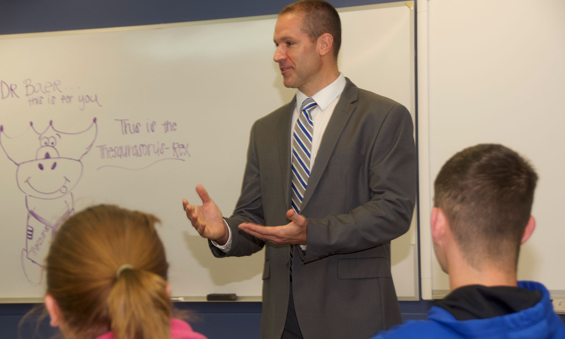 teacher standing in front of white board