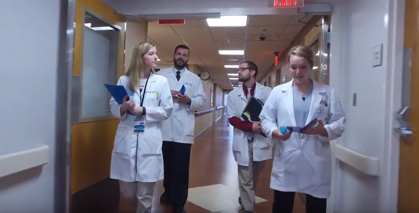 Four pharmacy students walk down a hallway