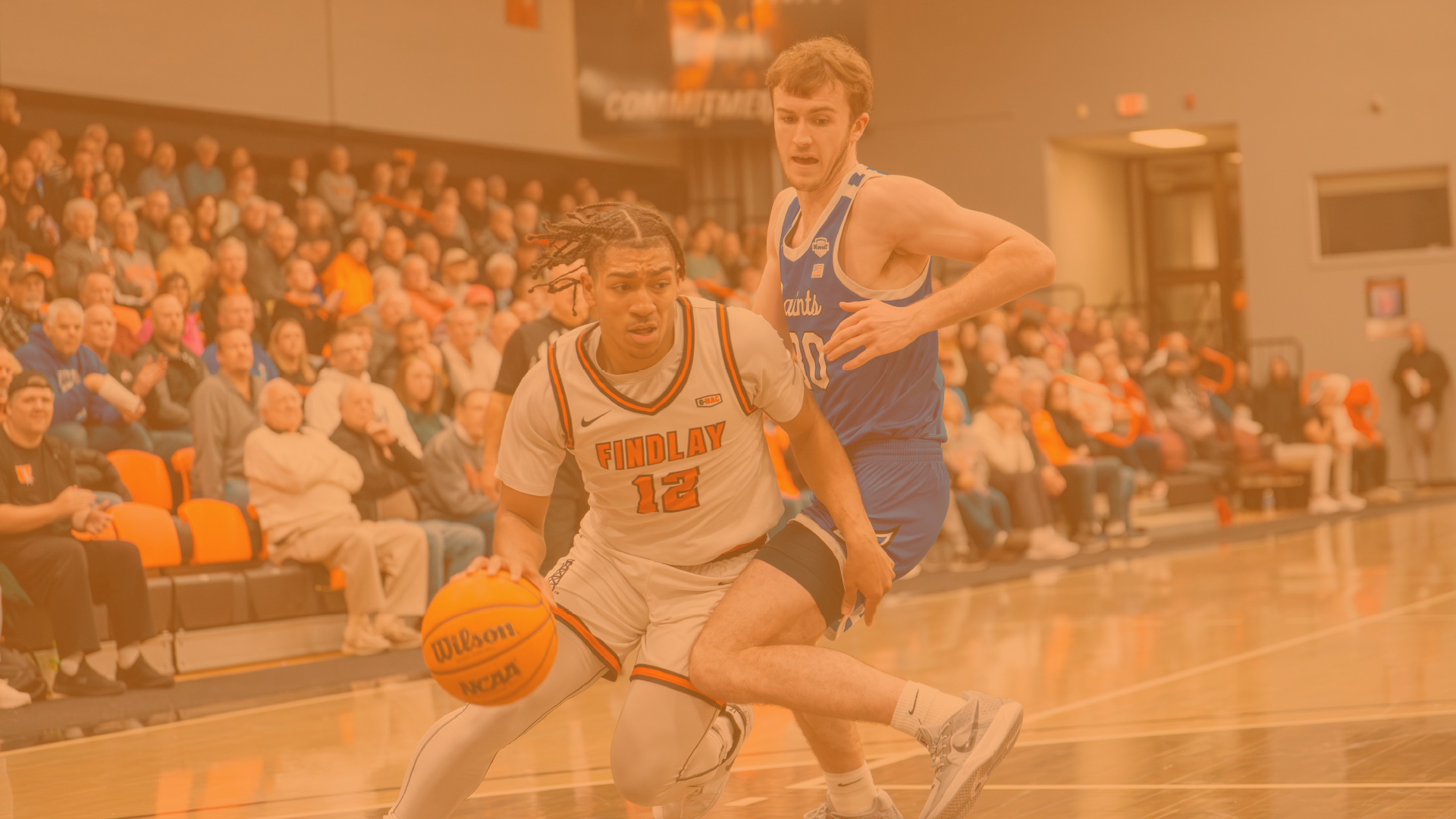 University of Findlay men’s basketball player dribbles past a defender during a game.